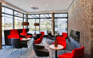 a lobby with red chairs and a fireplace at Holiday Inn Express Karlsruhe - City Park, an IHG Hotel in Karlsruhe