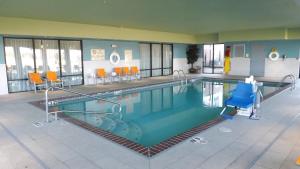 - une grande piscine avec des chaises orange dans un bâtiment dans l'établissement Holiday Inn Express & Suites Dyersburg, an IHG Hotel, à Dyersburg
