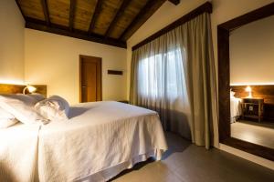 a hotel room with a bed and a window at Fazenda Verde - Praia do Rosa in Praia do Rosa