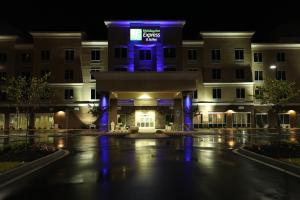 a hotel at night with a blue lit up sign at Holiday Inn Express Hotel & Suites Goldsboro - Base Area, an IHG Hotel in Goldsboro