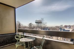 a balcony with two chairs and a view of a water tower at Holiday Inn Express Detroit-Birmingham, an IHG Hotel in Birmingham