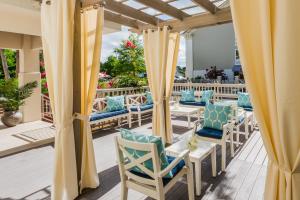 un patio con sillas y cortinas azules y blancas en Holiday Inn Express Fairhope - Point Clear, an IHG Hotel, en Fairhope