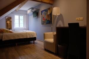 una camera con letto, finestra e sedia di Abeljano a Hasselt