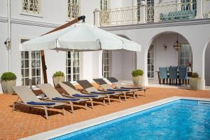 a pool with lounge chairs and an umbrella next to a swimming pool at Villa Luna in Vabriga