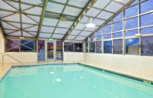 una grande piscina con un grande soffitto e finestre di Holiday Inn Express Ellensburg, an IHG Hotel a Ellensburg