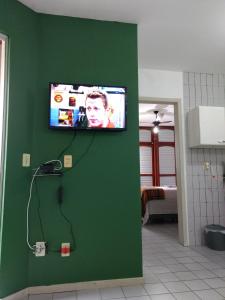 TV de pantalla plana en una pared verde en Santoro Gali 310, en Florianópolis