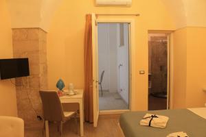 una camera con tavolo e una stanza con specchio di Arco Suite a Lecce