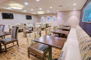 a dining room filled with tables and chairs at Holiday Inn Gainesville-University Center, an IHG Hotel in Gainesville