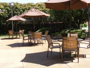 a group of chairs and tables with umbrellas at Holiday Inn Express Fredericksburg - Southpoint, an IHG Hotel in Fredericksburg