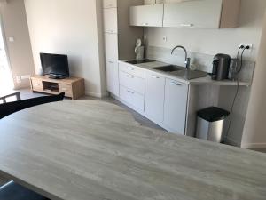 a kitchen with a large wooden table in a room at Appartement vue imprenable in La Rochelle