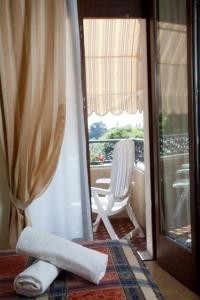 a room with a balcony with a chair and a window at Hotel Lory in Garda