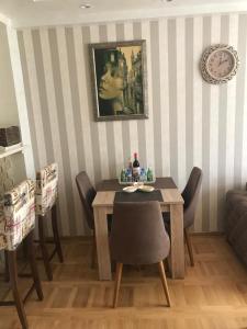 uma sala de jantar com mesa e cadeiras e um relógio em VIP Apartman KIKA Zlatibor em Zlatibor