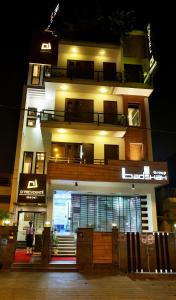 un edificio alto con una fachada iluminada por la noche en Hotel D'PRESIDENTE, en Nueva Delhi