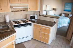 a kitchen with a white stove top oven next to a bed at Capitola Beach Suites in Capitola