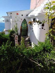 a white house with a door with a window at Hostal Piedra Andina in Copacabana