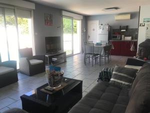 a living room with a couch and a table at LES CLÉMATITES in Donzère