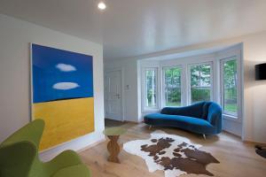 a living room with a blue couch and a painting at Casa Alchimia in Freeport