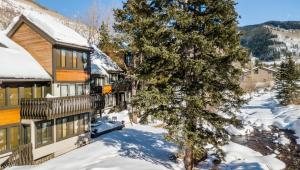 a house in the snow with a tree at Vail Racquet Club Mountain Resort in Vail