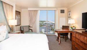 a hotel room with a bed and a desk and a window at One Ocean Resort and Spa in Atlantic Beach