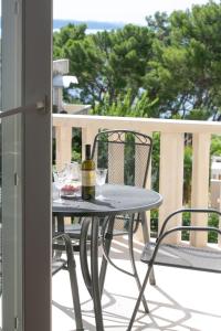 a table and chairs on a balcony with a bottle of wine at Apartment Angelina in Split