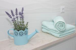 a blue vase with purple flowers on a bathroom counter at Apartment Angelina in Split +21 photos