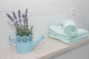 Un jarrón azul con flores púrpuras en el mostrador del baño en Apartment Angelina, en Split