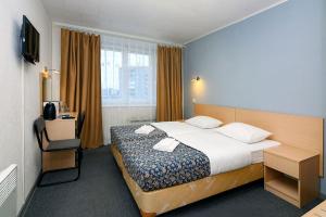 a hotel room with a bed and a desk and window at Ametist Hotel in Apatity