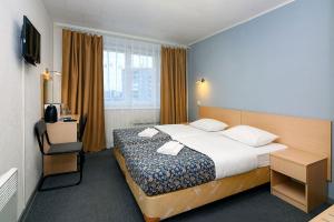 アパチートゥイにあるAmetist Hotelのベッド、デスク、窓が備わるホテルルームです。
