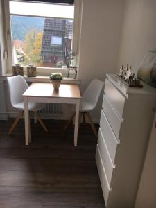 uma mesa e cadeiras numa cozinha com uma janela em Ferienwohnung Fuchsbau em Hahnenklee-Bockswiese