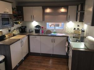 a kitchen with white cabinets and a sink at Logi - Bear in Felton