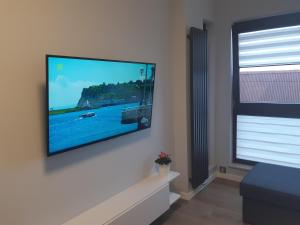 un soggiorno con una TV a schermo piatto su una parete di Apartament Chmielna - Waterlane Island a Danzica