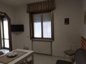 uma sala de estar com uma mesa e uma janela em Casa Vanna em Torre del Greco