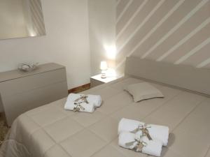 um quarto com uma cama branca e toalhas em Casa Vanna em Torre del Greco