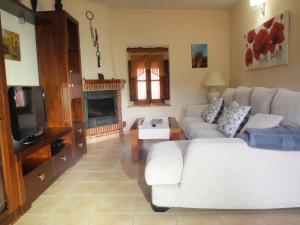 a living room with a white couch and a tv at LA CASA DE LAS AZAS in Casla