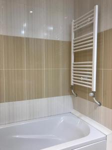 a white bath tub in a bathroom with a mirror at Iceberg Apartment 50 in Borovets
