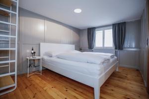 a bedroom with a large white bed and a window at MINA Stadtwohnung im Jüdischen Viertel in Hohenems
