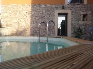 a swimming pool in a house with a stone wall at La Salceda in Torre Val de San Pedro