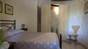 a bedroom with a bed and a chair and a window at Fleming 46 in Alghero