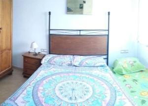 a bedroom with a large bed with a wooden headboard at APARTAMENTO EN SEGUNDA LINEA DE MAR, WIFI & A.C in Cubelles