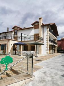 a large house with a patio in front of it at La Posada de Ojebar Nórdica in Rasines