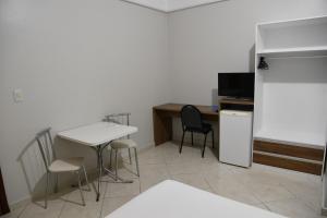 a kitchen with a table and chairs and a refrigerator at Hotel Mais in Macapá