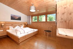 een slaapkamer met een bed in een houten kamer bij Kinderbauernhof in Schoppernau