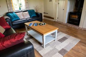 Thatch Cottage - luxury Norfolk Hideaway في نورويتش: غرفة معيشة مع طاولة قهوة وأريكة