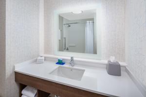 a white bathroom with a sink and a mirror at Holiday Inn Express Ontario by IHG in Creekside