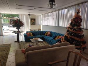 uma sala de estar com um sofá azul e uma árvore de Natal em Olga Kehdi Residence em Campo Grande
