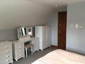 een slaapkamer met een bed en een bureau met een spiegel bij The Loft in Congleton