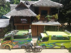 two trucks parked in front of a house at RYJ's Inn in Siquijor