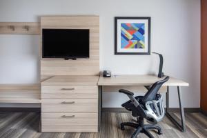 a desk with a television and a chair in a room at Holiday Inn Express Ontario by IHG in Creekside