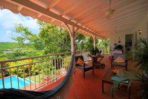 een veranda met een hangmat en een zwembad bij Villa with swimming pool and garden view MQSA20 in Sainte-Anne