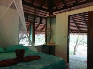 ムック島にあるCashew Nut Bungalow, Ko Mookのベッドルーム(緑のベッド1台、窓付)